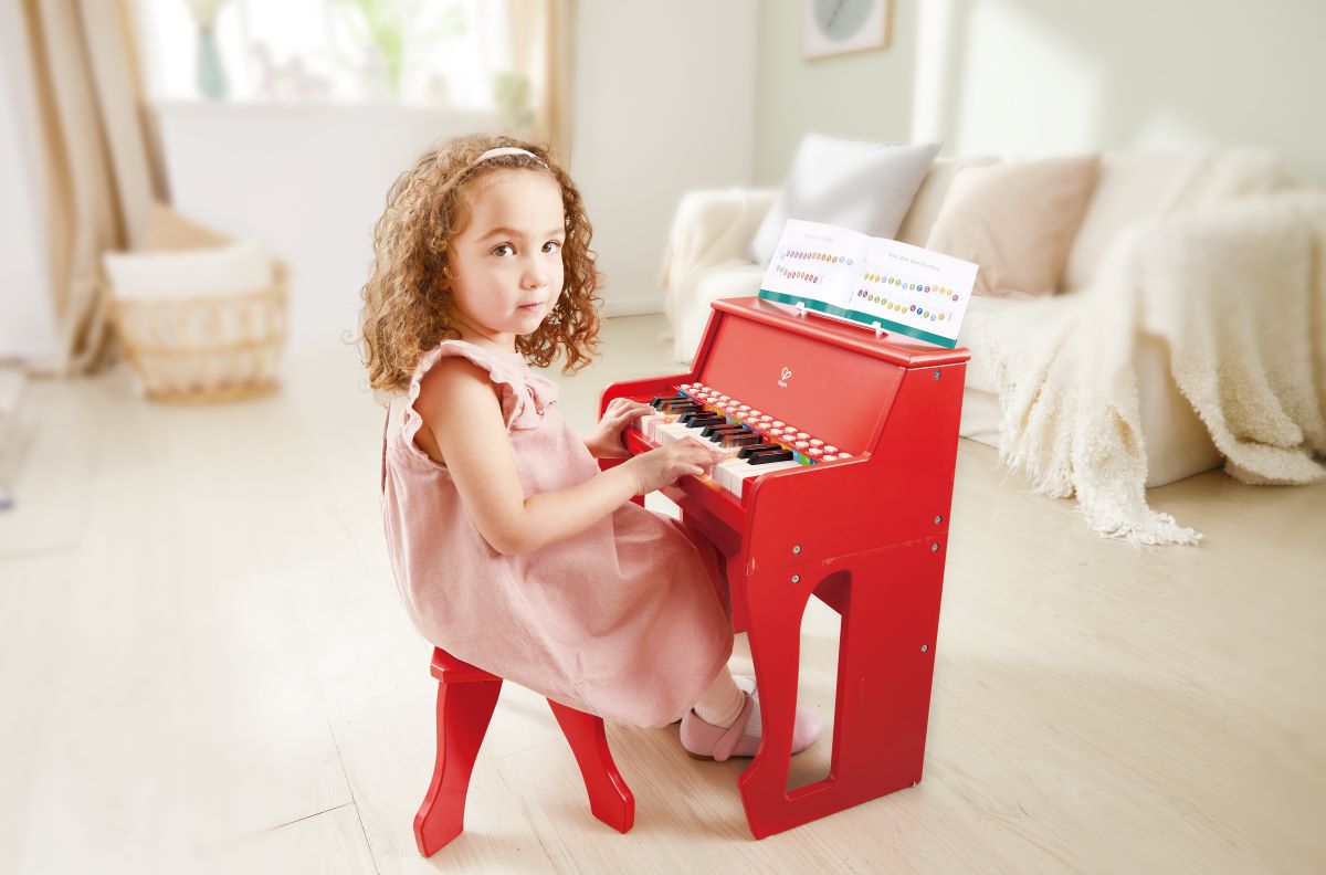 Piano de madera rojo con asiento